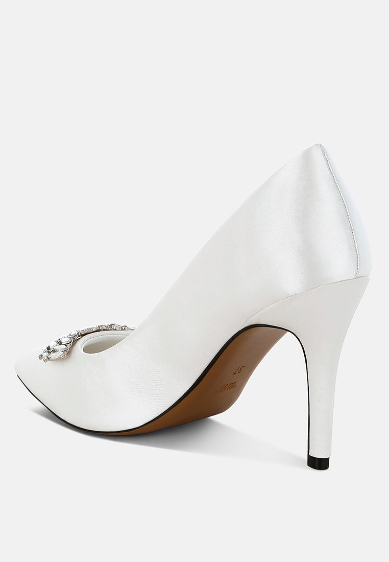 White Diamante Brooch Detail Satin Pumps by London Rag – satin pointed-toe pumps with a diamante brooch detail, stiletto heel, and cushioned insole, angled view